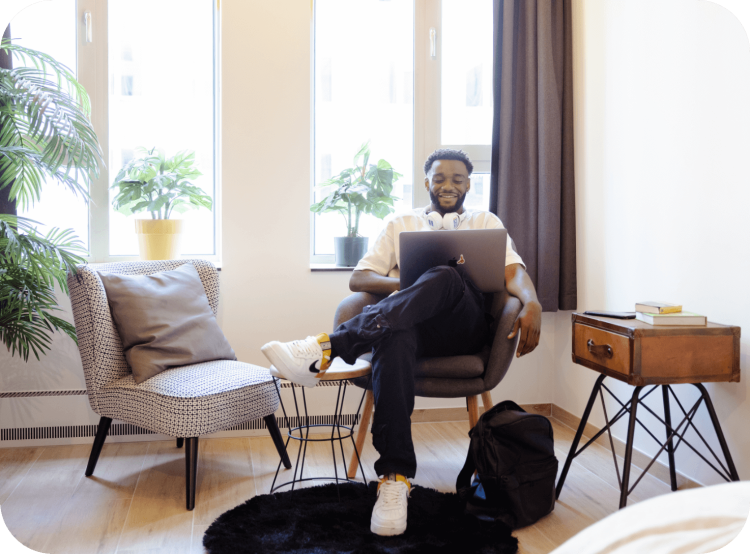 Student met laptop in een moderne Upkot studentenkamer van Upgrade Estate, waarin je kan investeren met je vennootschap