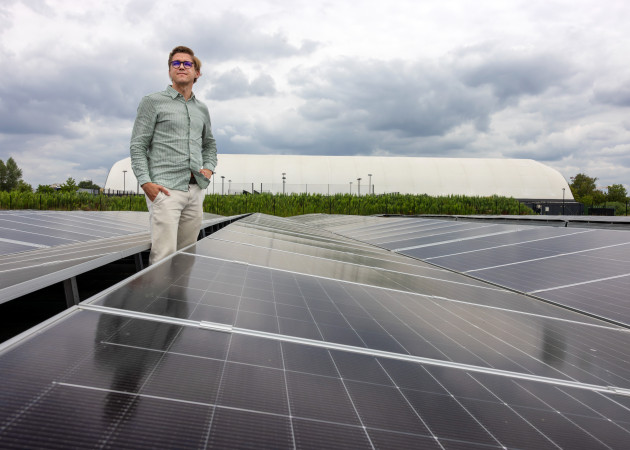 Jeroen van climate action tussen de zonnepanelen van de solar farm van Upgrade Estate op The Loop in Gent. 